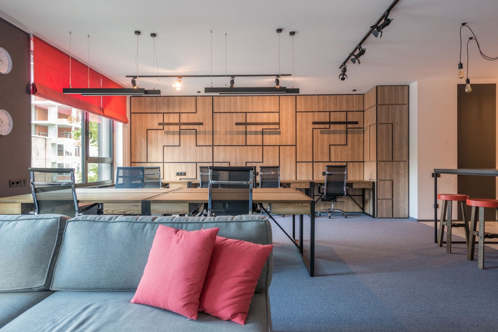 Spacious interior filled with modern furniture under a row of hanging lamps