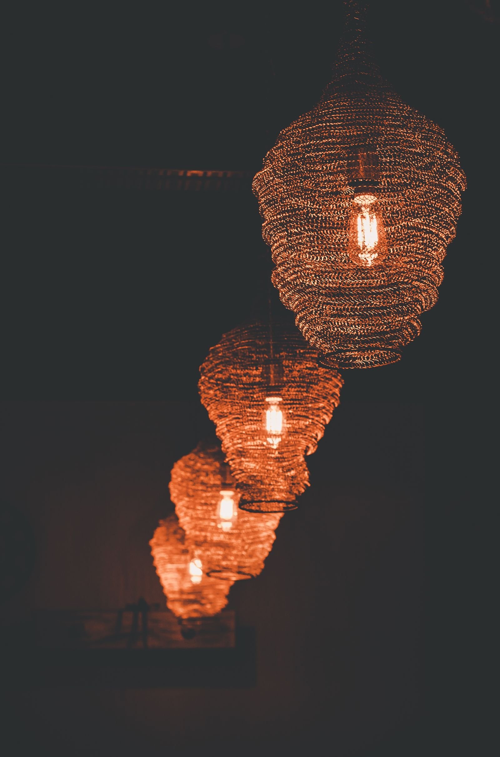 Cluster of brown pendant lamps casting a warm glow over a dim room