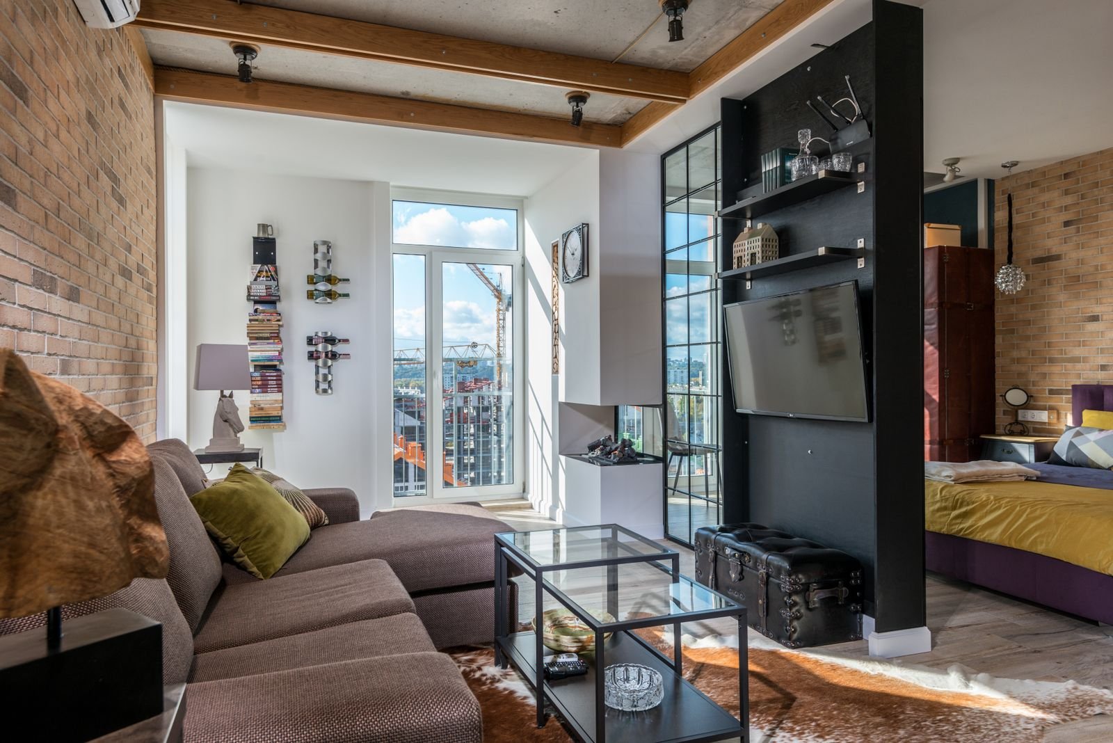 Bright open-plan loft living area with a sofa, coffee table and tall windows