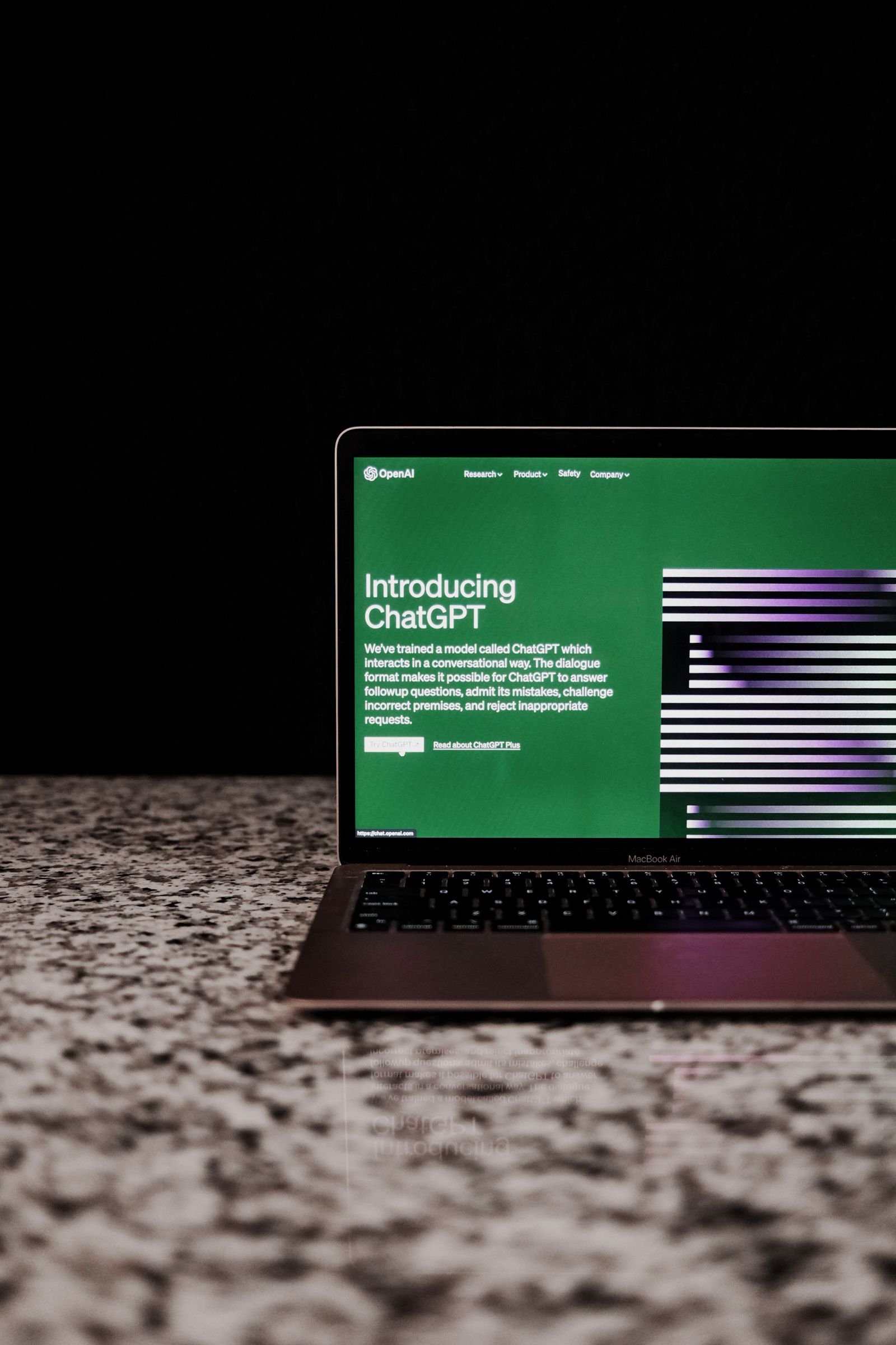 Open laptop on a marble surface showing an AI chatbot interface on screen