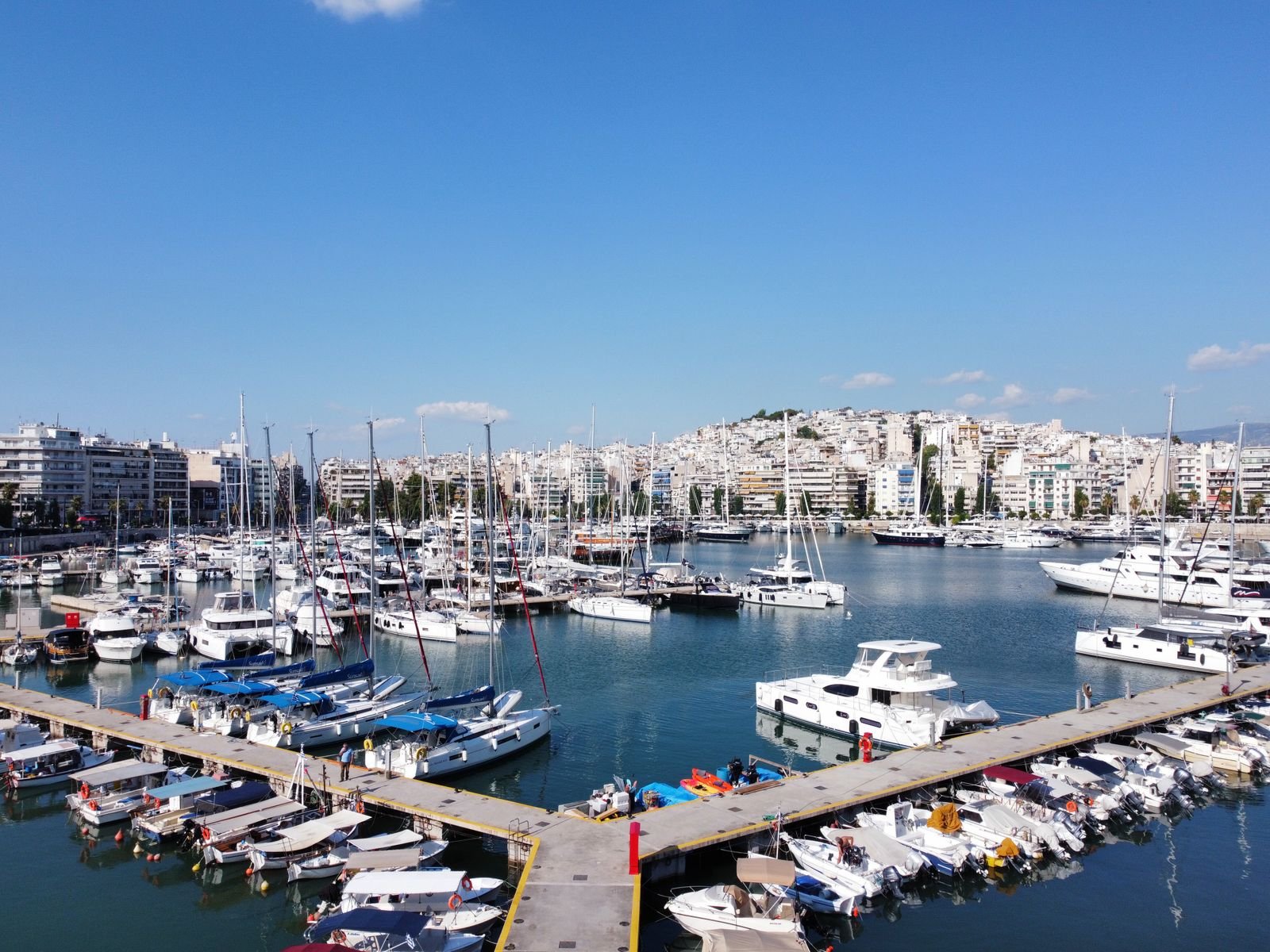 Rows of small boats moored along marina docks under a clear sky
