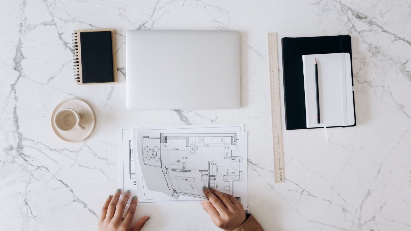 Architect's work table with blueprints, a laptop, notebook and drafting tools