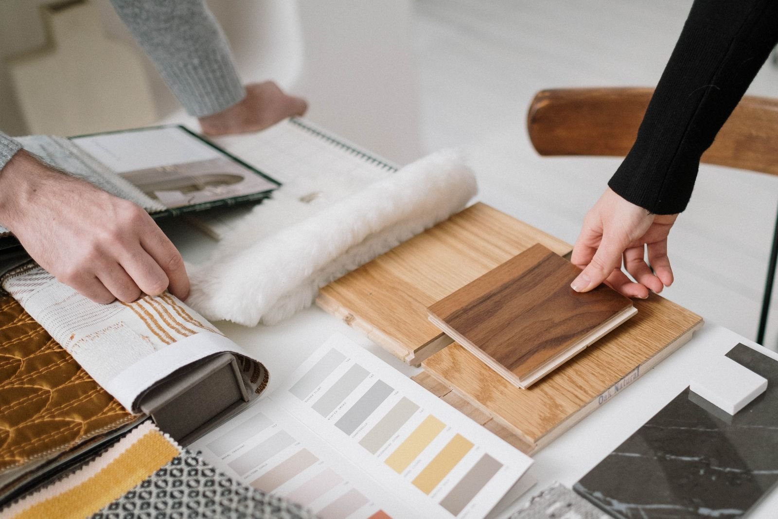 Hand holding wooden plank samples in different finishes