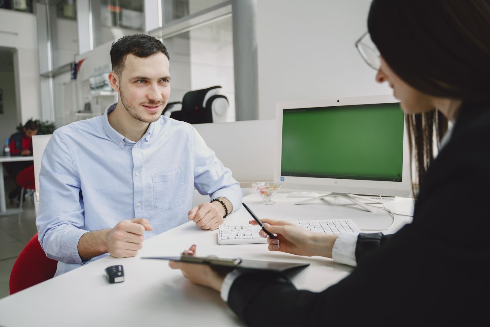 Two people seated across a desk in an office during a work meeting