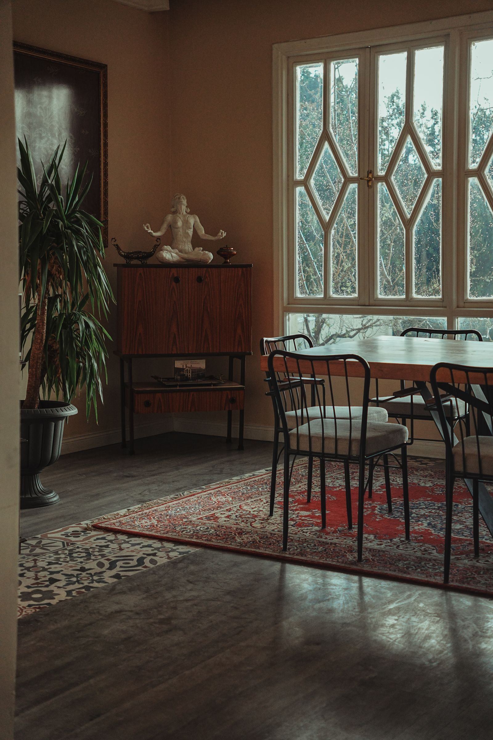 Vintage-style dining room with a wooden table and sunlight falling across the wall