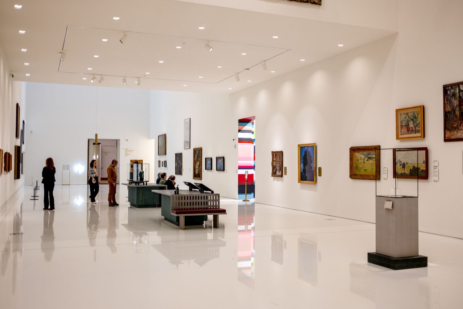 Interior of a modern museum with visitors walking between exhibits