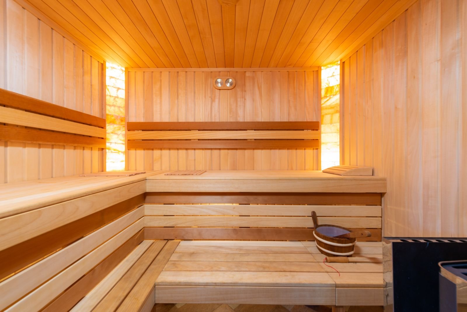 Empty wooden sauna interior with slatted benches and warm light