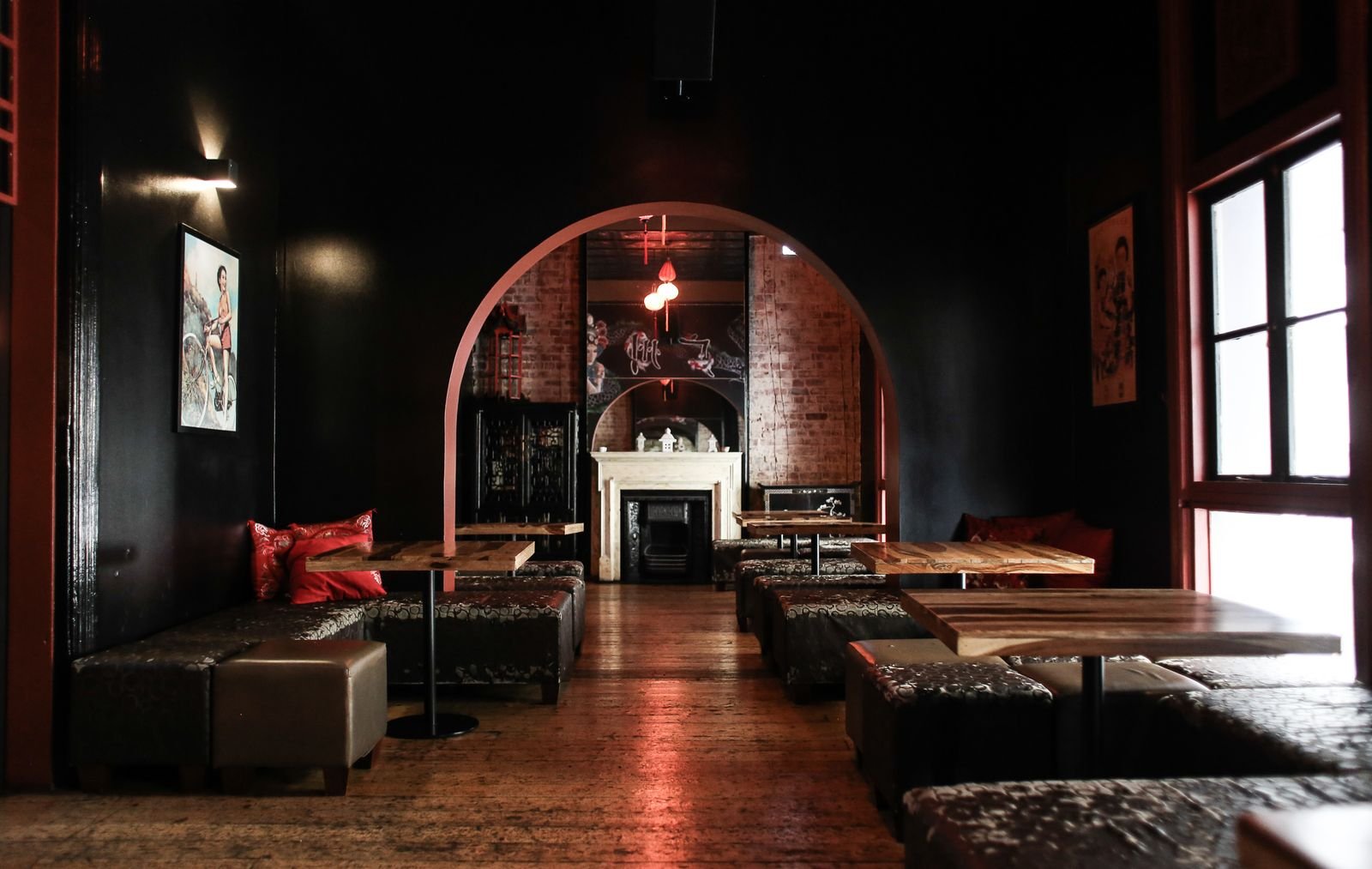 Dimly lit lounge bar with arched openings and upholstered seating