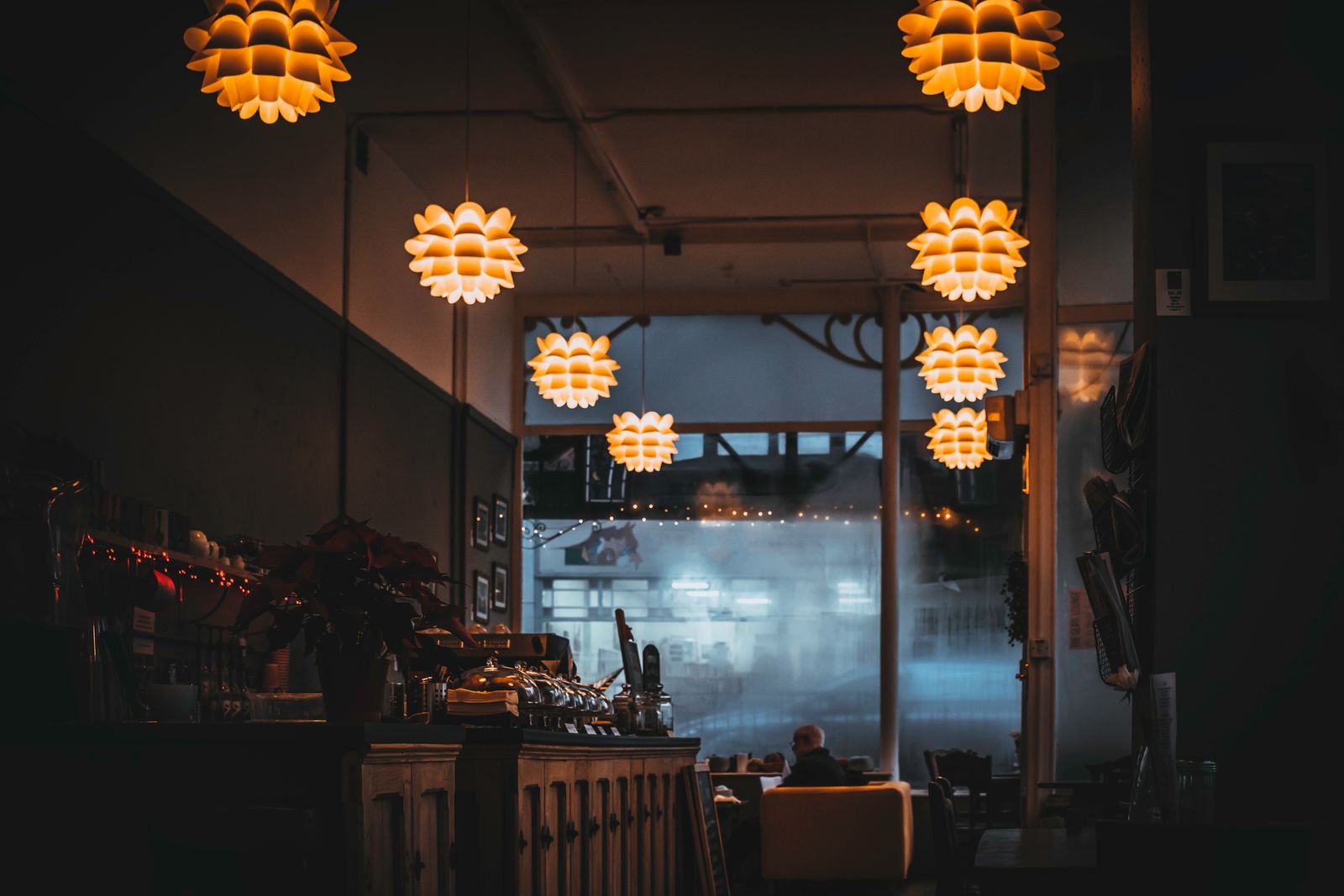 Warm-lit restaurant interior with decorative pendant lamps hanging over tables