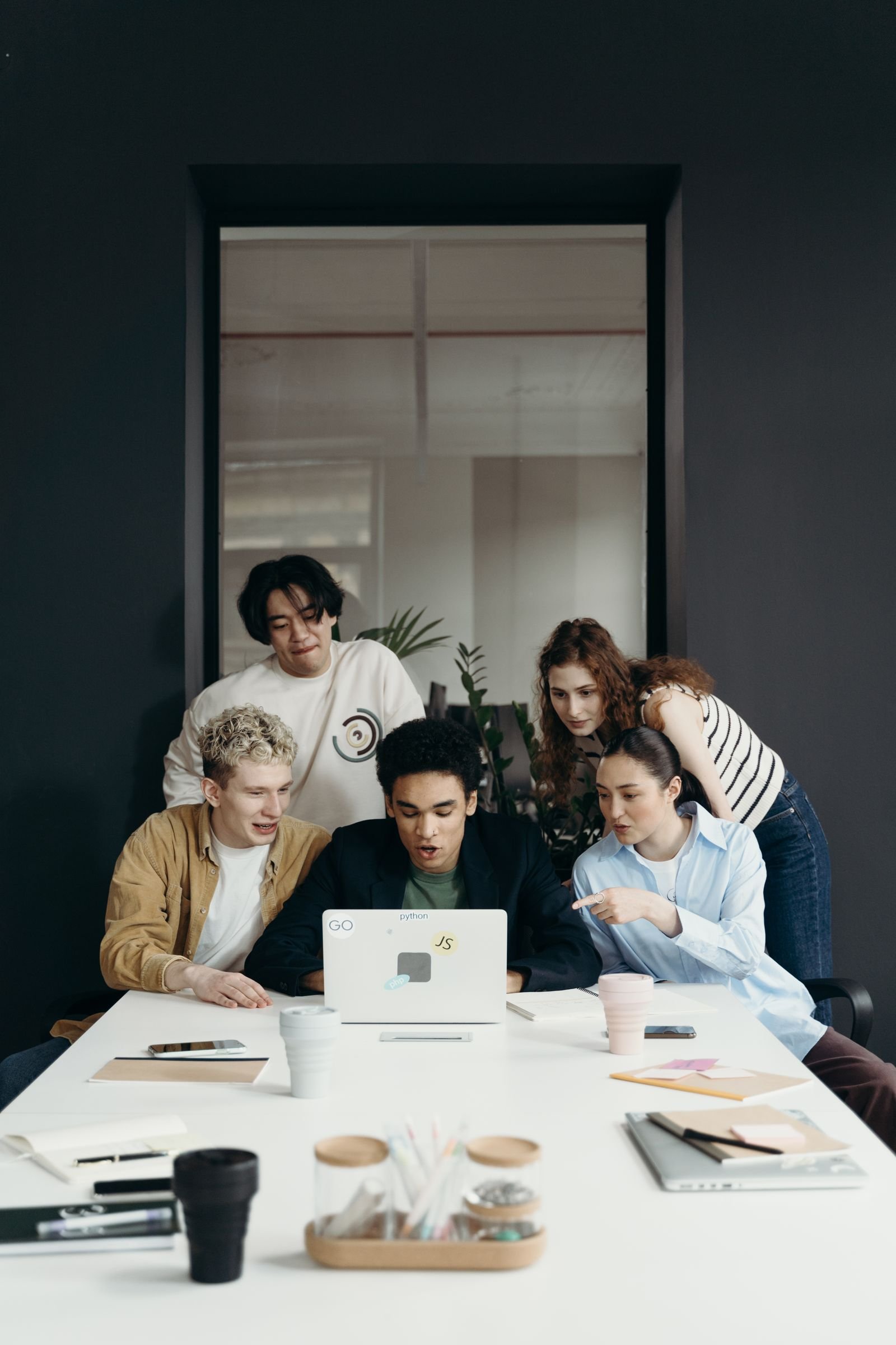 Young professionals gathered around a laptop in a contemporary studio