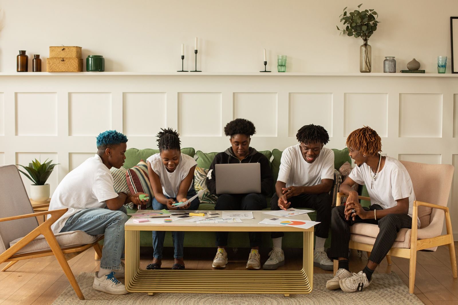 Group of young adults collaborating over papers and materials spread on a table