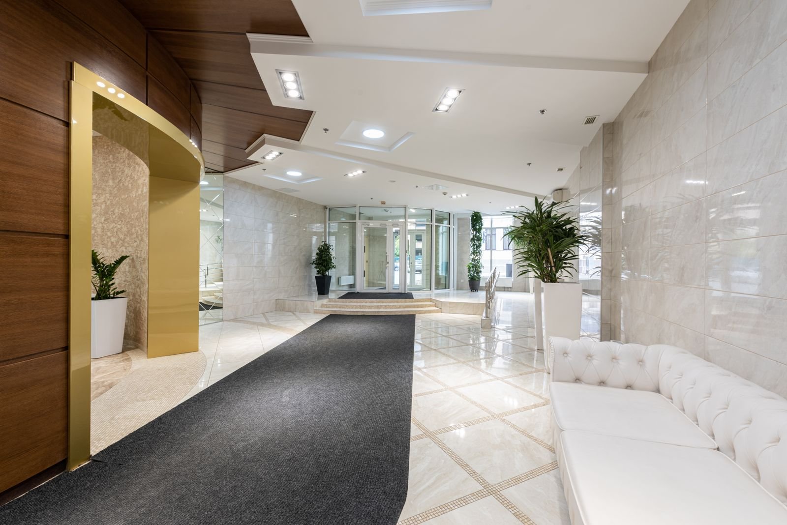 Modern hotel lobby with high ceilings, stone finishes and lounge seating